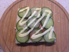 再均匀地摆上黄瓜片，挤上沙拉酱。