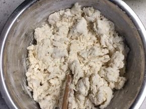 面粉放在盆里，一边加开水一边搅拌成雪花状。