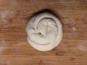 从一边开始往里盘，最后把收尾处塞在饼底。依次将所有的小面团都盘成小饼。