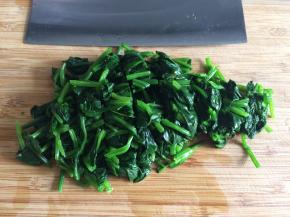 将菠菜从冷水中捞出，轻轻挤去水分，切成小段。