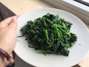 切好的菠菜放在盘子里，撒上盐和炒香的芝麻，再淋上香油拌匀即可。