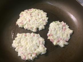 煎锅中小火刷一层油，用勺子舀一勺米饭混合物，并用勺背轻轻刮成小薄饼。