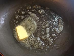 平底锅开火加热，放入一小块黄油融化。