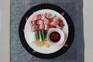 将五花肉均匀切成大方块，大葱切段，生姜切片