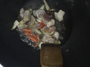 锅内放油，倒入调料炒香。并倒入肉进行翻炒, 肉炒变色后加入土豆豆角翻炒。