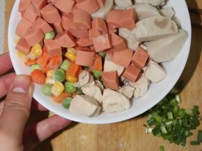 将墨鱼丸两次对切成丁，西红柿切丁，胡萝卜切丁，火腿肠切丁，小葱切粒，豌豆，玉米粒备好待用