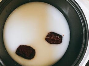 锅中加入两碗水，然后将材料倒入锅内，最后再加入牛奶搅拌均匀，盖上锅盖，定时。