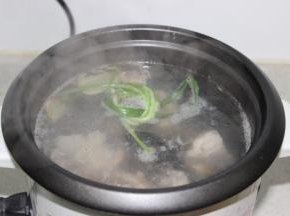 将焯过水的排骨放入电饭煲内，加入新的姜片和葱，加入热开水，烧开后滤沫煮半小时