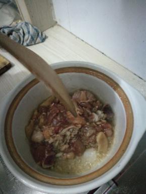 开火，把锅烧热两分钟后倒入油，油烧热后加入冰糖，烧至融化后倒入姜和蒜翻炒，倒入鸡块，用锅铲炒匀。