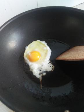 开火，锅热后将鸡蛋打入锅中，煎好备用。
