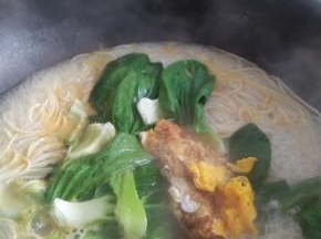 将青菜及煎好的鸡蛋放入，煮一分钟至青菜煮软。
