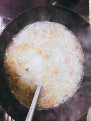 锅内加油倒入小葱和辣椒炒香，加入冬瓜、胡萝卜、金针菇翻炒并加入两碗清水。