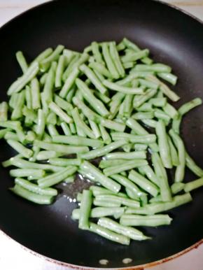 热锅冷油，油热后放入锅中煸炒，炒制豆类水分散发，干香油亮即可。干煸豆角比较费火，要小火不断的煸豆角，直至出现虎皮即可。