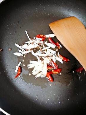 锅内留的底油可直接加热后放入蒜、姜、花椒和干辣椒炒出麻香味。