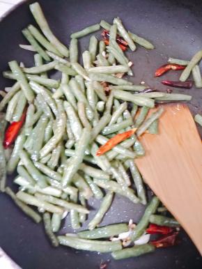 放入豆角继续翻炒，加盐和鸡精调味即可。
