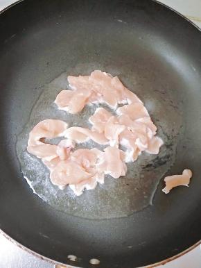 热锅冷油，放入鸡胸肉快速翻炒，待肉变色后放入辣椒。