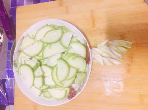 西葫芦切片，葱白切丝。