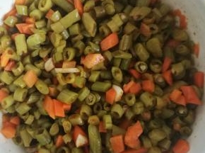 将切好的酸萝卜和酸豆角放入碗中，将大蒜切丁一起放入碗中加盐搅拌均匀