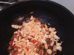 倒入油豆腐，大蒜和干辣椒，翻炒