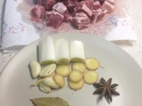 牛腩切小块放清水里浸泡去血水，多换几次水直到无血水渗出，放厨房纸吸干表面水分备用。葱切大段，姜切片，大蒜拍扁备用。