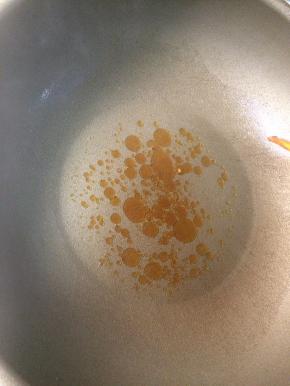 起锅热油，下一小把冰糖，小火炒至冰糖融化出现焦糖色后马上下入牛腩转大火翻炒。