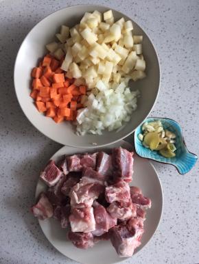 土豆、胡萝卜、洋葱切丁，排骨剁小块浸泡去掉血水，葱蒜切末，姜切片。