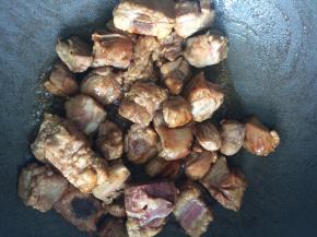 锅内倒油，放入几颗冰糖，冰糖融化后下排骨翻炒。