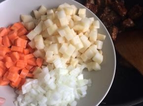 加入葱姜蒜，将所有排骨翻炒至金黄发亮后下入蔬菜丁。