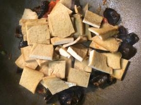 下木耳翻炒均匀后，加入豆腐块继续翻炒。