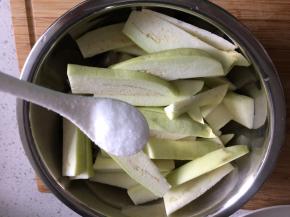 蒜切蒜末，茄子洗净去皮切成条状，加入一勺盐拌匀腌15分钟。