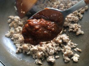 锅内放入比平时炒菜略多一点的油，下入蒜末炒香后，下腌制好的肉末翻炒至肉末变白变散，加入两勺豆瓣酱翻炒均匀。