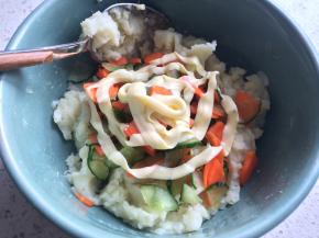 将胡萝卜和黄瓜挤掉水分放进土豆泥中，挤上沙拉酱。