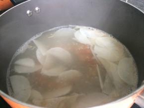 下入白萝卜片翻炒均匀后，加入足量清水大火煮开后转小火10分钟。