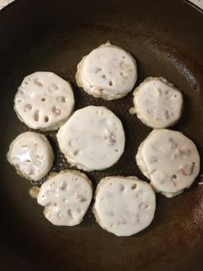 起锅热油，将做好的藕夹裹满面糊放入平底锅小火煎制。