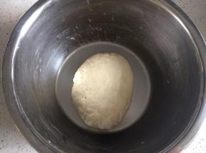 温水里加一点盐，加入面粉中和成光滑的面团，盖上盖子醒30分钟。在这期间可以切些蒜末备用。