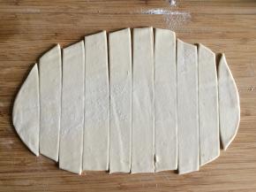 将醒好的面在案板上擀成先薄片，再切成均匀宽度的长条。