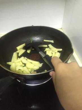 将土豆片用水冲洗掉表明淀粉，放入热锅中翻炒