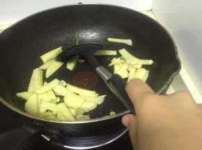 将土豆片用水冲洗掉表明淀粉，放入热锅中翻炒