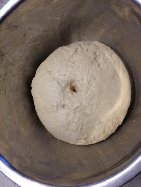 面团发酵至两倍大取出，撒上干面粉彻底排气，再次揉成光滑的面团。