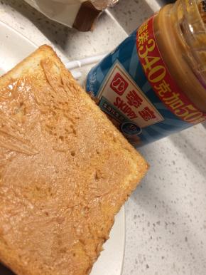 在一片吐司的一面抹上花生酱，将另一片吐司盖在上面，然后在第二片吐司朝上一面也抹上花生酱。