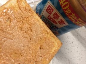 在一片吐司的一面抹上花生酱，将另一片吐司盖在上面，然后在第二片吐司朝上一面也抹上花生酱。