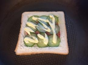 放上火腿片，均匀地铺上黄瓜片，挤上沙拉酱。