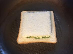 盖上挖出的吐司，用铲子压几下使三明治更紧实后翻面。