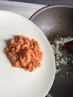 起锅爆香蒜末，下入泡菜丝炒出香味。