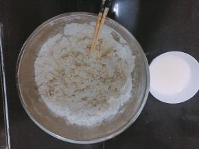 用温水将酵母粉化开后倒入面粉内搅拌。