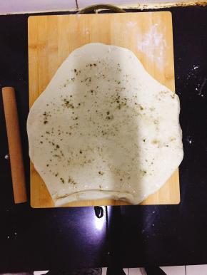 将发好的面团加入苏打粉揉匀擀成面片，均匀的加上一层植物油、盐和苦豆子粉卷起。