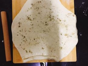 将发好的面团加入苏打粉揉匀擀成面片，均匀的加上一层植物油、盐和苦豆子粉卷起。