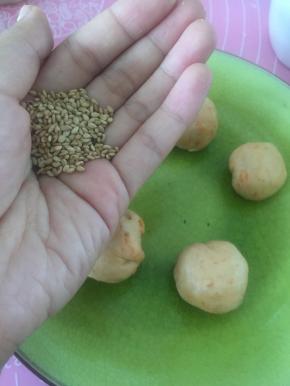 拿出熟芝麻，裹在面团上