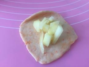 取一小团面，将面团擀开，加入土豆丁。