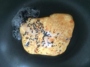 用淀粉和黑芝麻混合，将芡汁浇在饼上